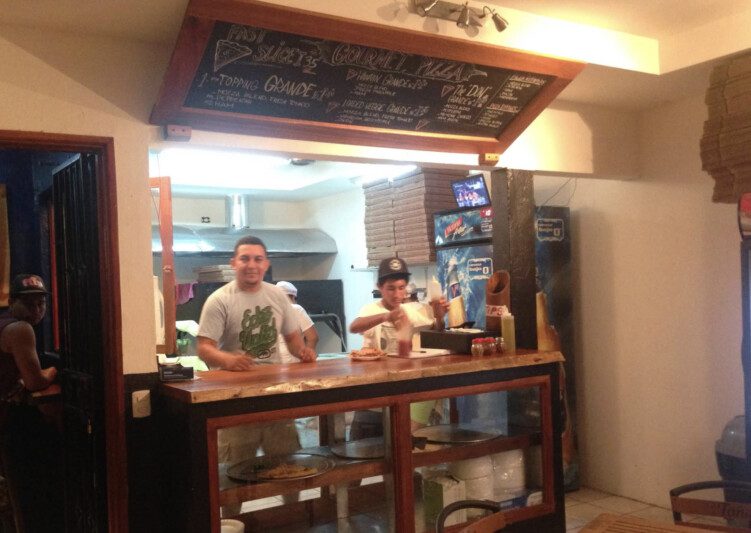 Freshly baked pizza slices at Don Monchis Pizzería in San Juan del Sur, Nicaragua