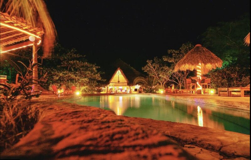 Outdoor dining area of Mango Rosa Restaurant & Bar in San Juan del Sur, featuring pool, tropical ambiance and open-air seating.