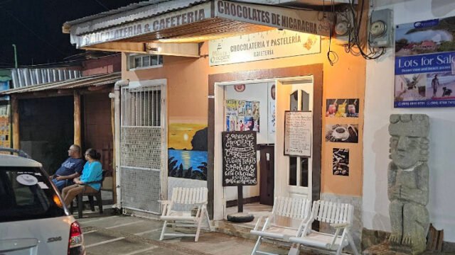 Surf Town Hostel's rooftop terrace overlooking San Juan del Sur with guests enjoying the sunset