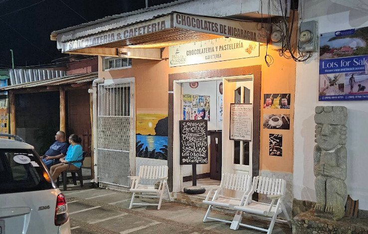 Surf Town Hostel's rooftop terrace overlooking San Juan del Sur with guests enjoying the sunset