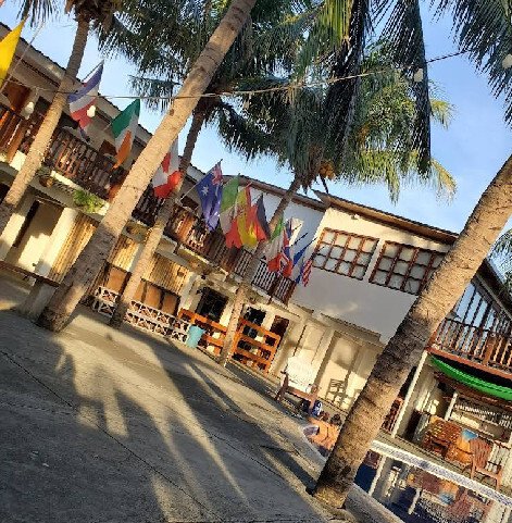 View of Hotel Anamar's beachfront pool area with guests enjoying the sun and ocean breeze in San Juan del Sur, Nicaragua