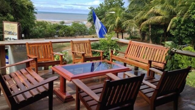 Hostal y Restaurante Villa Mar exterior view with beachfront setting, colorful facade, and shaded outdoor dining area in San Juan del Sur
