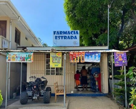 Farmacia Estrada storefront in San Juan del Sur, Nicaragua, offering a wide range of pharmaceutical services