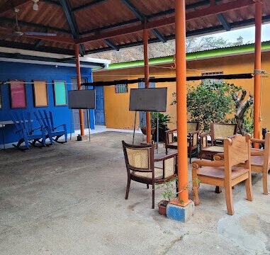 Open-air Spanish classroom with students and local teacher under a shaded patio in tropical San Juan del Sur setting