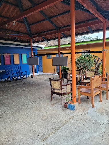 Open-air Spanish classroom with students and local teacher under a shaded patio in tropical San Juan del Sur setting