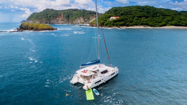 Close Up Shot of Santana Sail Yacht with People swimming in the water behind